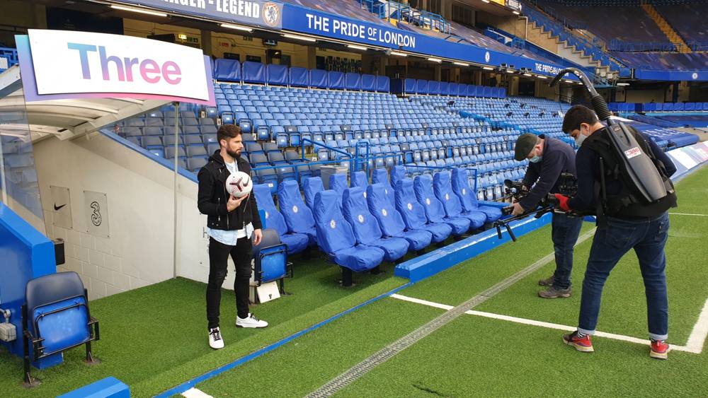 Filming a player holding a ball beside the Chelsea bench