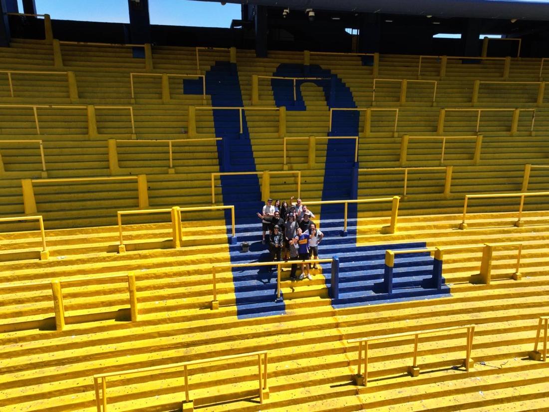 The crew posing in an empty yellow and blue stand in Buenos Aires