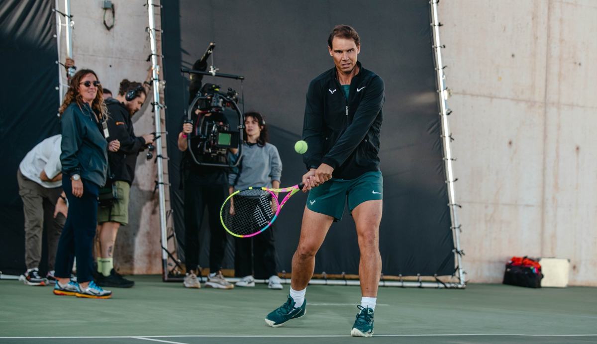 Rafael Nadal hitting a backhand with the crew behind him
